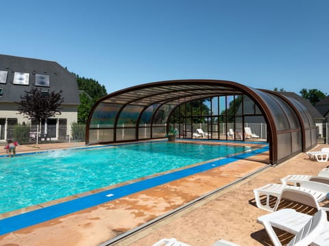 Sunlit outdoor pool with retractable cover, ideal for relaxing after exploring Deauville and the Pays d’Auge.