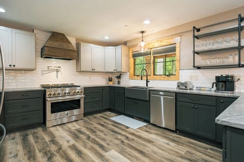 The kitchen features a gas range with a pot filler and farm sink.