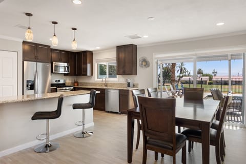 The dining table sits right between the kitchen and living room with golf course views.