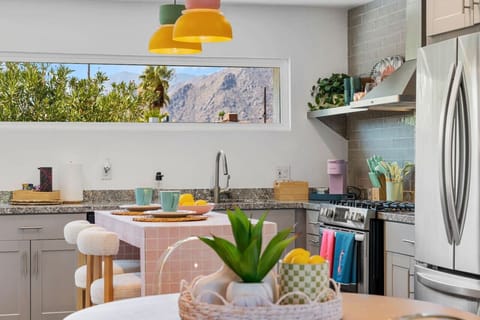 Bright dining nook w/ playful art, modern tableware & a welcoming spot to start the day.