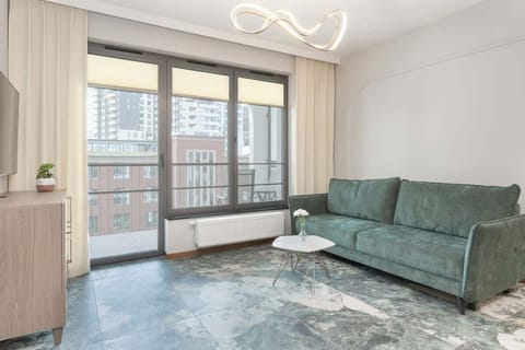 Living area with a sofa bed, Smart TV and access to balcony.