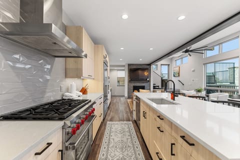 Full kitchen with stainless steel appliances and breakfast bar.