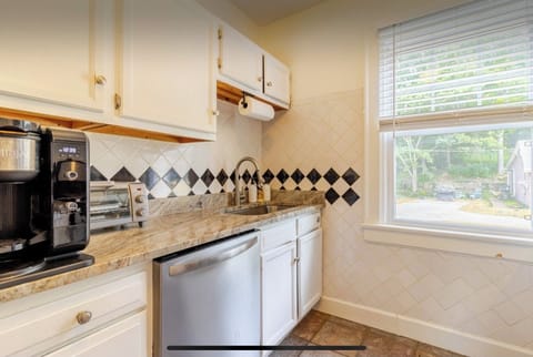 The kitchen is equipped with stainless steel appliances, a Ninja coffeemaker.