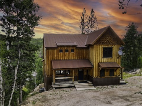 Your home in the Black Hills — the kind of cabin that stops you in your tracks before you even open the door. Warm light, pine trees, and three floors of memories waiting inside.