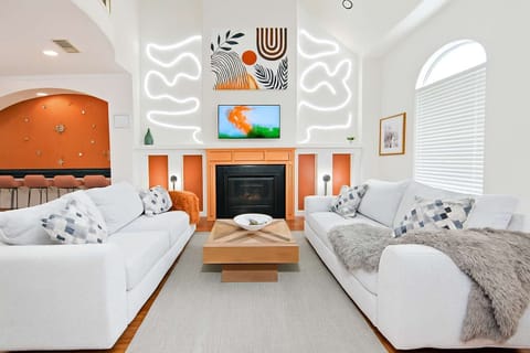 Living room with gray sofa, bright windows, and modern wall art