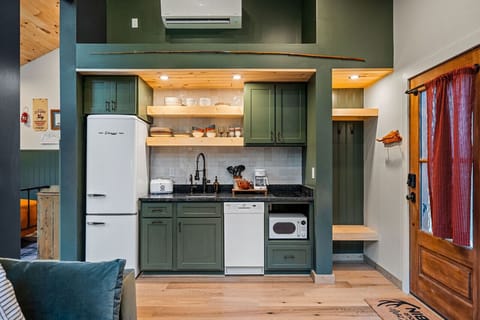 The kitchen features a two-burner electric cooktop, ice maker, microwave, toaster, blender, dishwasher, and refrigerator, along with a coffee maker that uses our custom Hideout coffee blend.