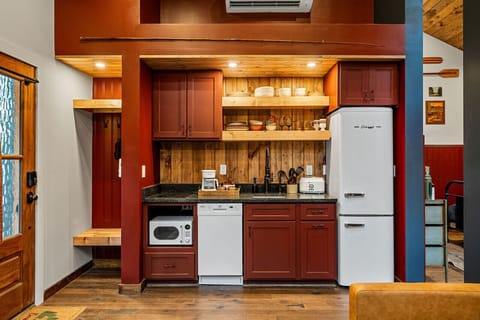 The kitchen features a two-burner electric cooktop, ice maker, microwave, toaster, blender, dishwasher, and refrigerator, along with a coffee maker that uses our custom Hideout coffee blend.
