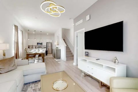 The living room exuded warmth and charm, featuring a plush sofa nestled between two elegant armchairs, creating a cozy and inviting atmosphere.