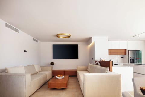 The cozy living room features two lush sofas to unwind, an 86” TV, and a PlayStation 5 to enjoy all the fun!