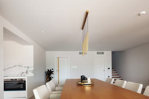 Nearby, the elegant 10-seat dining table awaits, inviting you to create unforgettable meals and moments with your loved ones.