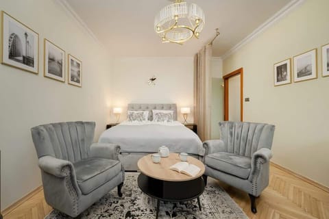 A cozy yet sophisticated living space with velvet armchairs, a round wooden coffee table, and elegant wall art, creating a welcoming and stylish atmosphere.