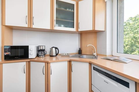 The kitchen's sleek design includes all necessary cookware and utensils.