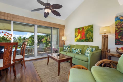 Unwind in your breezy tropical living room, where vibrant green furnishings and lush palm artwork create a relaxing island vibe. Step through sliding doors to your private balcony overlooking palm trees and sunshine.
