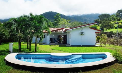 A tranquil house nestled in greenery, featuring a beautiful pool.
