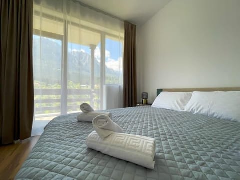 The first bedroom featuring a queen-size bed equipped with freshly cleaned linens, fluffy pillows, soft towels, bedside table, room-darkening shades, standard TV and a wonderful mountain view