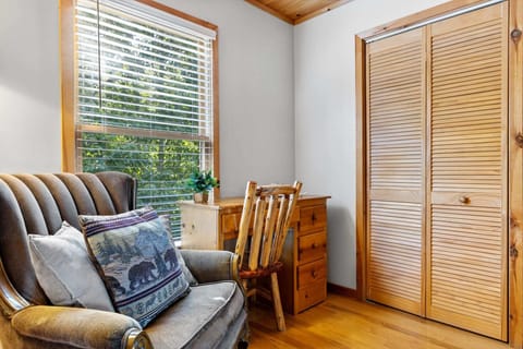 Enjoy a stylish and practical corner in the bedroom with plush seating and a classic wooden desk and chair