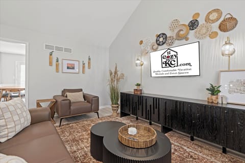 Upper-level living room with comfortable seating, a large Smart TV, and a warm, modern design perfect for relaxing after a day exploring KC.