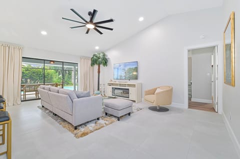 Bonita Vanderbilt - Living with electric fireplace and smart TV. Sliding doors open up to the screened in pool area