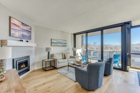 Relax by the fireplace & enjoy the bright, airy living space with comfy seating and a balcony view! 