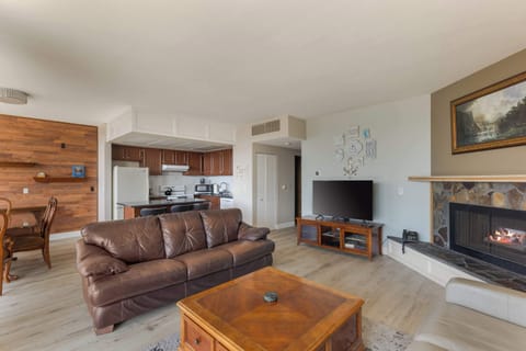 Your vacation home awaits! Enjoy this spacious living area with a fireplace, smart TV, and convenient kitchen access.