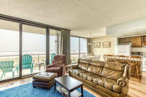 A modern, open-concept living space with large windows, cozy seating, a spacious dining area, and a bright, inviting atmosphere. 
