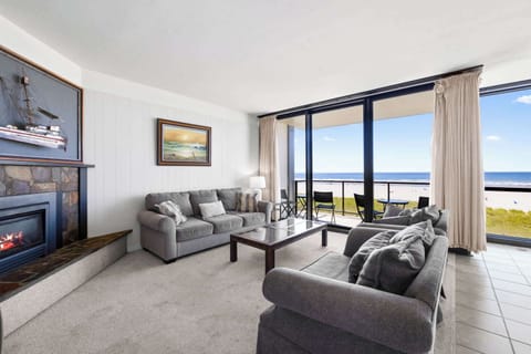 Unwind with a view! Spacious living room, warm fireplace, and a balcony overlooking the sparkling ocean.
