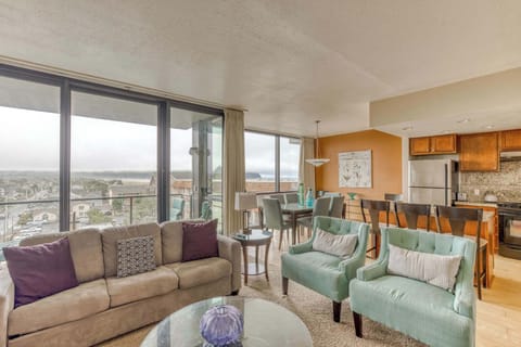 A modern, open-concept living space with large windows, cozy seating, a spacious dining area, and a bright, inviting atmosphere. 