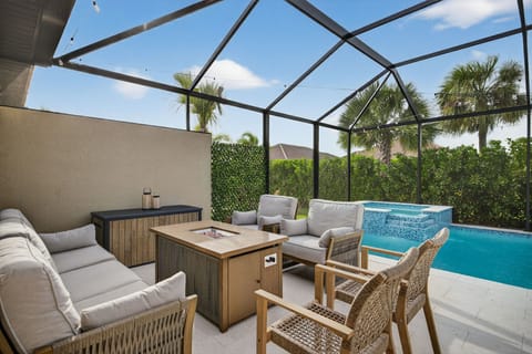 lounging area with fire pit overlooking pool and hot tub