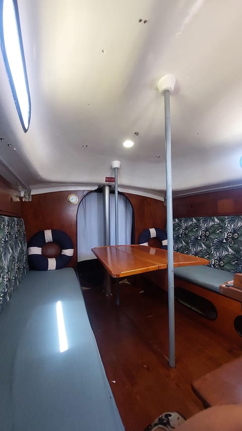 Salão com a cama de mar/sofá cama à esquerda da imagem e a mesa aberta.