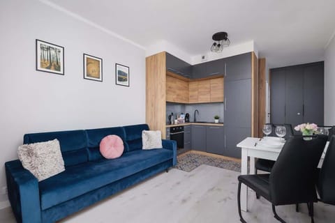 A modern living room with a blue sofa, wooden accents, and decorative wall art.