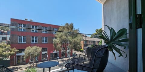A breezy, sun-drenched balcony overlooking a charming streetscape.