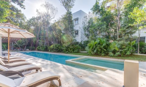 Relax by the sparkling pool surrounded by lush tropical greenery.