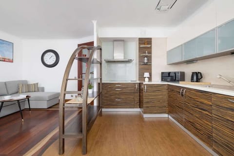 Spacious kitchen with a modern design, dark cabinets, open shelves, and built-in appliances.