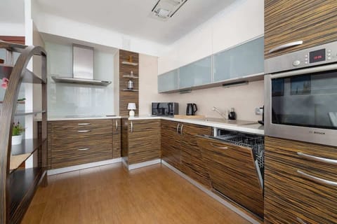 Spacious kitchen with a modern design, dark cabinets, open shelves, and built-in appliances.