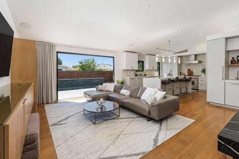 Open concept living room and kitchen with sleek cabinetry and a central island.