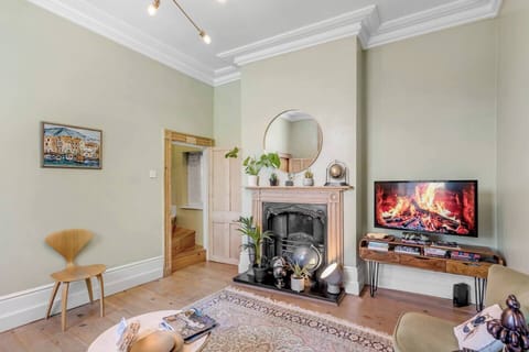 Cosy up in the inviting living room, featuring a comfortable sofa, and a large TV for your entertainment. Perfect for relaxing after a day of exploring! 🔥🛋📺