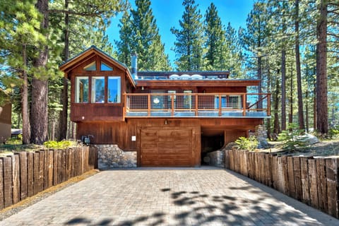 A stunning modern mountain cabin nestled among towering pines, featuring natural wood architecture and contemporary design elements.