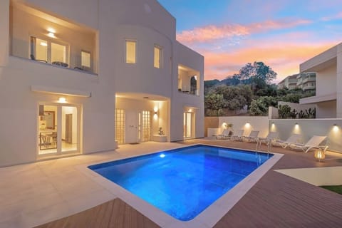 POOL | Enjoy the enchanting evening ambiance with beautiful illumination, complemented by comfortable sun loungers, umbrellas, and coffee tables.