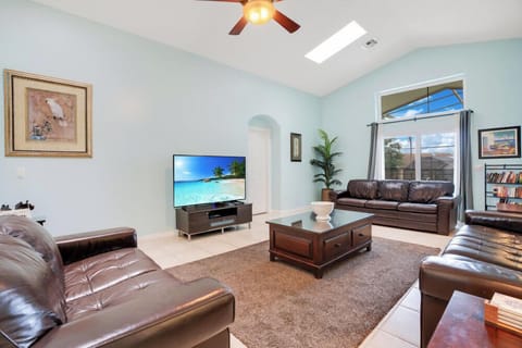 Spacious living room with leather sofas and natural light from skylight and windows