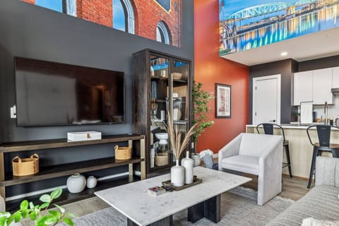 Living room with Smart TV, two queen Murphy beds, and private patio access