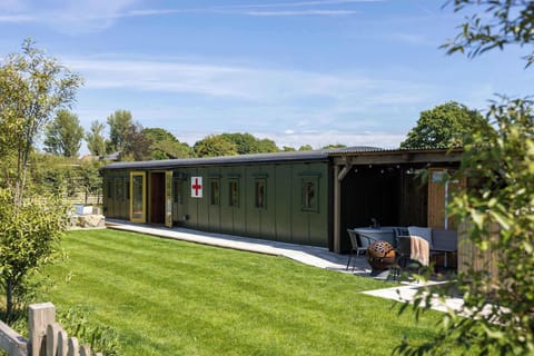 Experience a piece of history in our beautifully restored WW2 ambulance train carriage. Relax in the serene outdoor seating area with lush green surroundings.