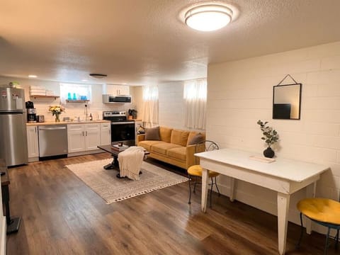 Bright open-concept living space with full kitchen, dining area, and coffee station in this Denver Highlands garden-level vacation rental