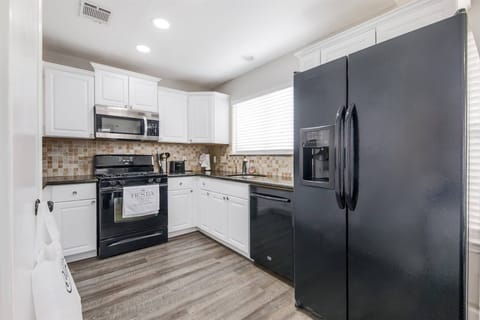 Fully equipped kitchen with electric stove, microwave, full fridge, dishwasher, coffee maker, and cookware—everything you need to prepare and enjoy meals during your stay.