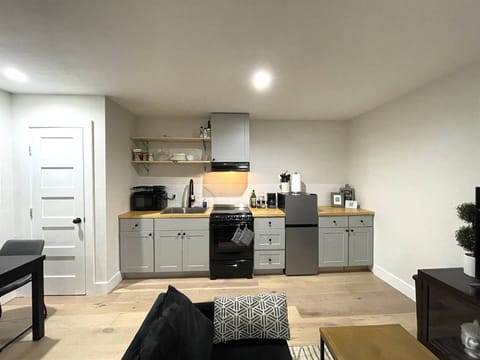 Modern kitchenette with open shelving, essential appliances, and plenty of counter space for your cooking needs.