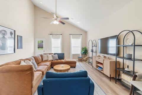 Comfortable and stylish living room with a roomy leather sectional, contemporary décor, and plenty of natural light—ideal for relaxing or entertaining!
