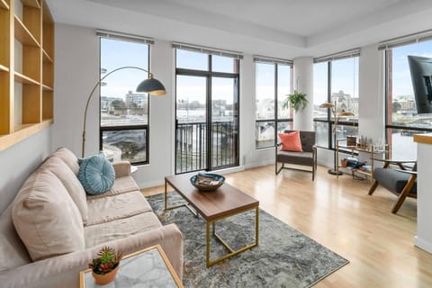 Expansive, curved open-concept main living room surrounded by wrap-around windows featuring direct harbor and bridge views.
