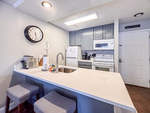 Modern kitchen with bar seating and all essentials, perfect for cooking and casual conversation