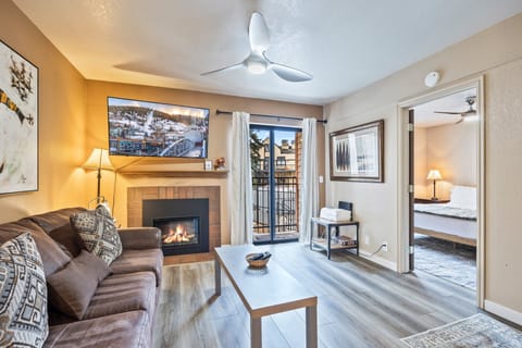 Cozy living area featuring a gas fireplace, comfortable seating, and an open layout connecting to the bedroom and balcony—ideal for relaxing after a day in Park City.