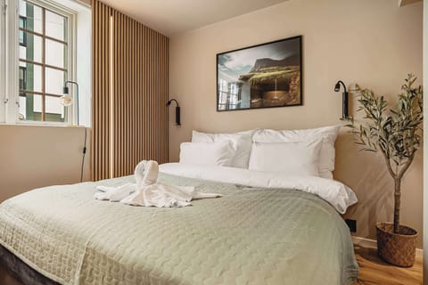 Serene bedroom with lush bedding, cozy decor, and charming window view