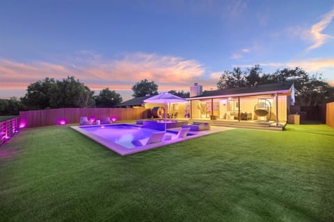 Private resort-style backyard featuring a heated pool and spa with massaging jet